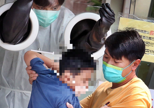 兒童染疫人數不斷增加，不少家長帶孩子去採檢。（本報系資料照）