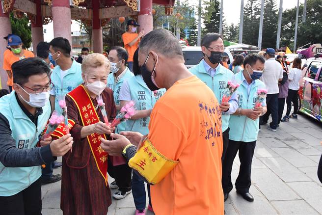 柯妈妈带领民眾党参选人们一同赠送康乃馨给在场信徒。（谢明俊摄）