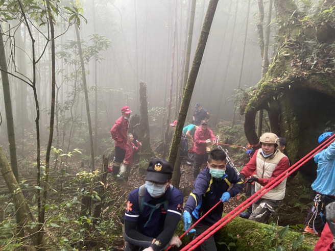 南投县消防局与搜救人员下午合力以绳索拖拉中，要将走失三天的沈姓阿嬷带离溪谷。（南投县消防局提供／卢金足南投传真）