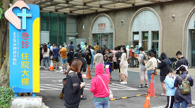 中央流行疫情指挥中心今天宣布，为纾解医疗量能，明（8日）起将隔离门槛降到7天，7天后无须採检自动解隔。图为民眾到急诊大楼外的快筛站採检。（图／姚志平摄）