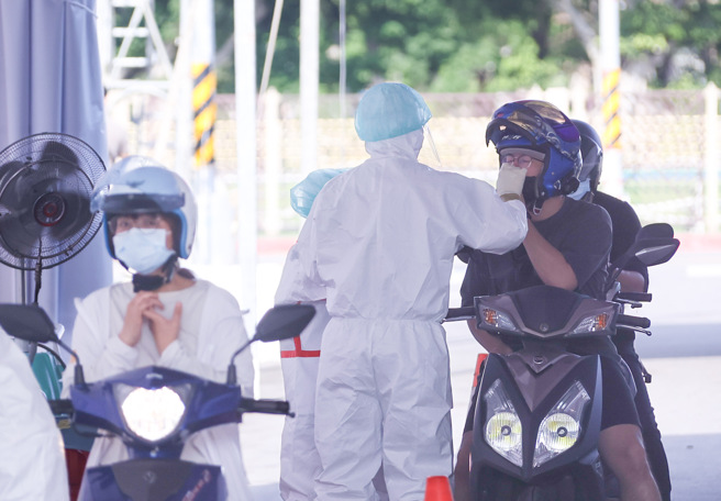 中央流行疫情指揮中心今天公布國內新增中重症新增118人，中症106人、重症12名。 示意圖為許多民眾騎乘機車前往車來速做篩檢。（羅永銘攝）