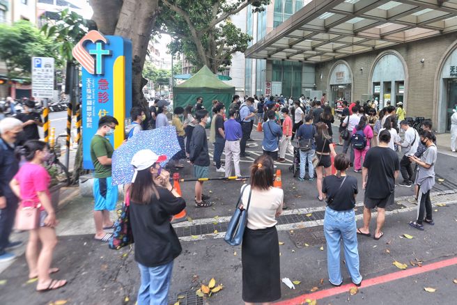 为确保医疗量能，卫福部要求各县市加开专责病房，其中北、北、基、桃，急性一般病床500床以上医院，须加开至3成。图为民眾在急诊大楼外等候採检。（资料照）