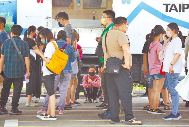 新冠肺炎疫情升溫，6日本土確診新增3萬6168例，醫院PCR採檢量大增，中央流行疫情指揮中心宣布190家診所加入採檢行列。圖為北市聯醫篩檢站外大排長龍，民眾因等太久，蹲下稍作休息。（張鎧乙攝）