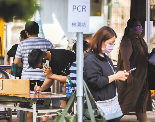有专家提出疫情高峰可能持续一个半月，卫福部长陈时中则说，这波Omicron特性来看，观察各国家疫情都来得很急，但并没有看到一个半月这么久。图为民眾前往筛检站做PCR前，仔细填写资料。（罗永铭摄）