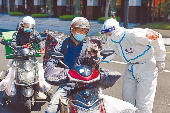 上海疫情趨緩，上海各級公安機關集中組織警力，持續展開「黑騎手」（非法外送員），圖為上海市公安局虹口公安分局，對跨區的快遞員進行逐一檢查。（中新社）