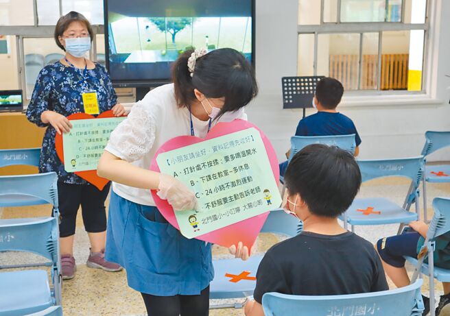 北門國小學童6日施打疫苗，工作人員詳細叮嚀打完疫苗後注意事項。（邱立雅攝）