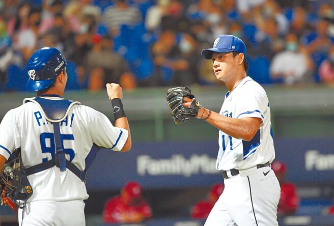 富邦悍将江少庆（右）对乐天桃猿先发7局无失分，与捕手戴培峰击掌打气。（张铠乙摄）