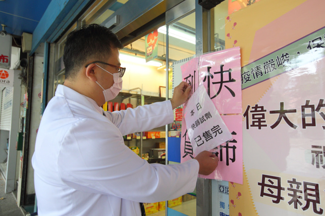 地方抱怨中央配發快篩試劑不夠，指揮中心指揮官陳時中回應，可自行購買。圖為一位藥師7日在藥局外貼上「本日快篩試劑已售完」的公告。（張鎧乙攝）