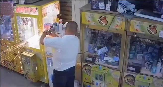 陆姓男子因为缺钱花用，自备砂轮机要切割娃娃机店的兑币机，导致火花四射。（翻摄照片／林瑞益高雄传真）