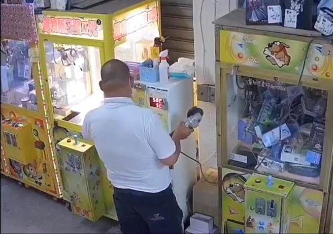 陆姓男子因为缺钱花用，自备砂轮机要切割娃娃机店的兑币机。（翻摄照片／林瑞益高雄传真）