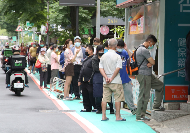 国内疫情大爆发，快筛试剂需求大增，即便政府于4/28祭出药局「快筛实名制」，引发民怨买不到，指挥中心规划，超商、药妆加入配合政府贩售快筛试剂，8日一处药局民眾大排长龙等待购买快筛试剂。（资料照/陈俊吉摄）