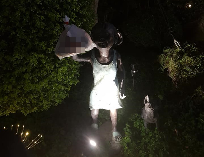 外送員將晚餐同樣掛在小女孩銅像手中。（圖／翻攝自爆廢公社）