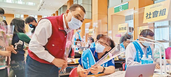 新北市長侯友宜（左）8日前往居家照護關懷中心慰問志工與市府員工，在母親節送康乃馨給志工。（陳慰慈攝）
