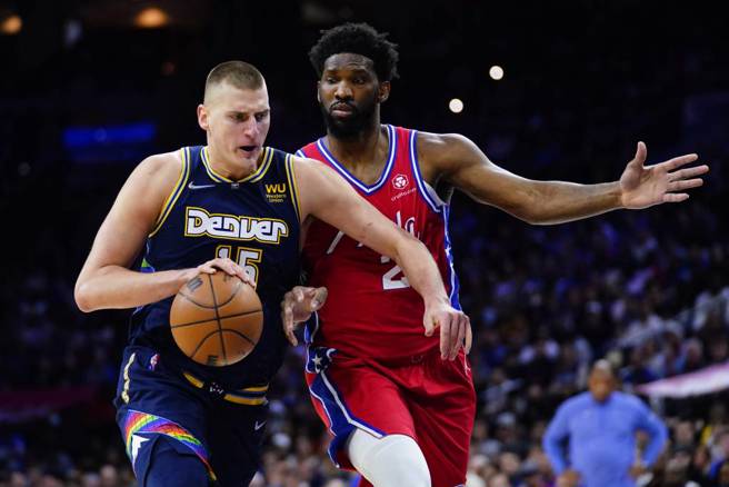 金块中锋约基奇（左）持球对抗七六人中锋恩比德。（美联社资料照）
