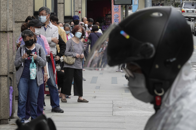 新冠疫情攀升，民眾抢购快筛试剂，在经济部协调下，具医疗贩售证的4大超商、卖场9日加入贩售行列，但许多民眾仍习惯一早到药局门口排队购买。（黄子明摄）