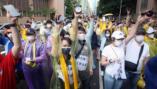 机师工会前往疾管署前陈情，要求机组员以筛代检、回归正常派遣，并呼吁决策公开透明。陈情结束前工会成员高举手机及时钟，要「唤醒沉睡的时中」。（范扬光摄）