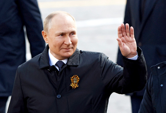 69歲的俄羅斯總統普丁9日出席勝利日閱兵儀式時，大腿蓋了一件綠色毛毯，令外界再度議論他的健康狀況。（圖／路透社）