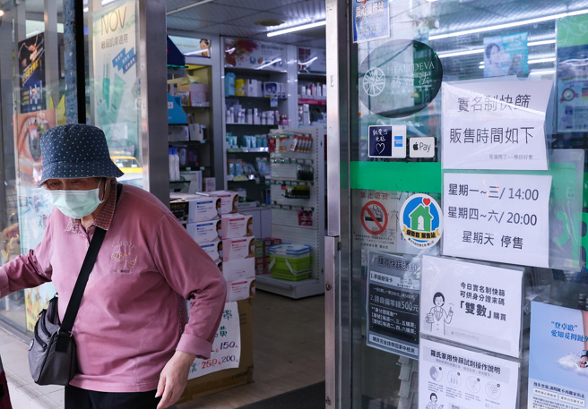 快篩試劑需求大增，有藥局在門口貼出實名制快篩販賣時間，以免民眾白跑一趟。(羅永銘攝)