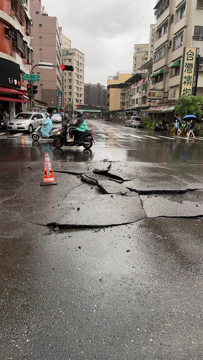 三民區凱旋路、憲政路口人孔蓋隆起，路面被擠壓成大裂痕。（翻攝照片／高雄洪靖宜傳真）