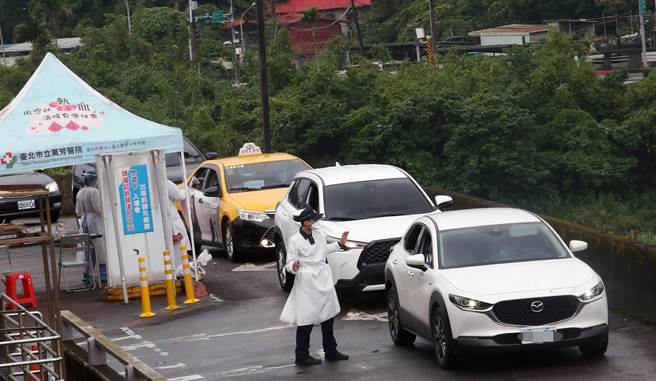 捷運木柵機廠停車場增設的「防疫急門診」11日起開始營運，預計每日可以為800名快篩陽性民眾PCR採檢。在木柵機廠內，員警忙著引導車輛指揮交通。（范揚光攝）