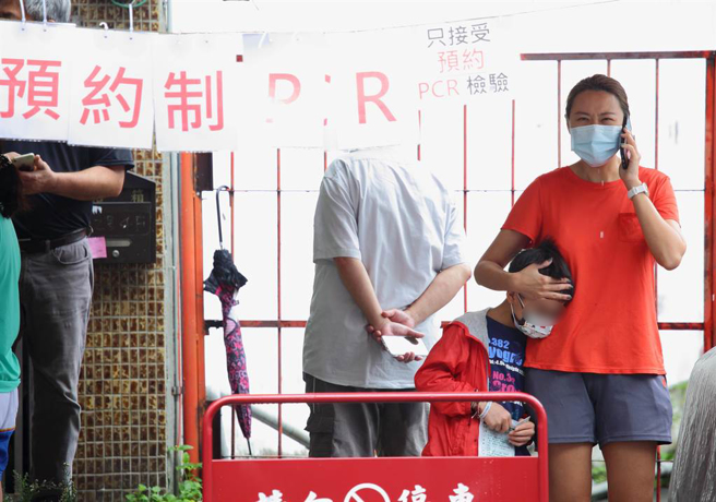 中央媒合全國190家診所提供PCR採檢，但不少診所反映尚未接獲中央配套措施，設備也未到位、無法實施，其中中央公布新北有44家診所配合，現僅有2家診所提供PCR篩檢。在台北市一家耳鼻喉科診所篩檢站外，一位小朋友因做完PCR篩檢不舒服，母親將他抱在懷中。（張鎧乙攝）