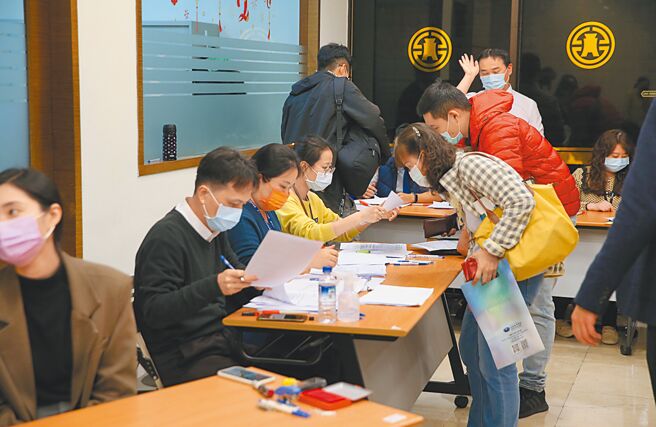 寿险公会昨同意以「数位新冠病毒健康证明」作为COVID-19诊断证明书的替代文件，但各产险公司仍未达成共识。图为民眾购买防疫保单，工作人员忙着审查送件。（陈君玮摄）