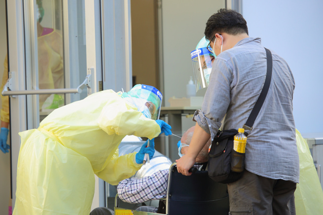 醫師指出喉嚨痛可以透過多喝水、少講話、用鹽水漱口、喝冰水、吃冰淇淋來舒緩。圖為本土疫情持續蔓延，醫護人員在戶外幫民眾篩檢。（資料照 張鎧乙攝）