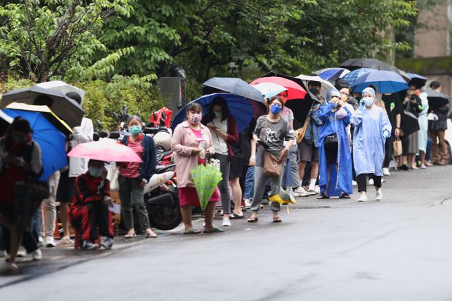 新冠疫情持續升溫，不少民眾排隊等待篩檢。（杜宜諳攝）