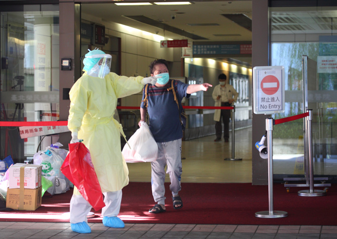 一位民眾在醫護的引導下步出新冠專責病房。（張鎧乙攝）