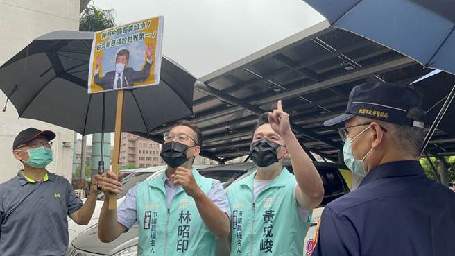 台灣民眾黨桃園區市議員參選人黃成峻在衛生局門口舉牌抗議。（陳夢茹攝）