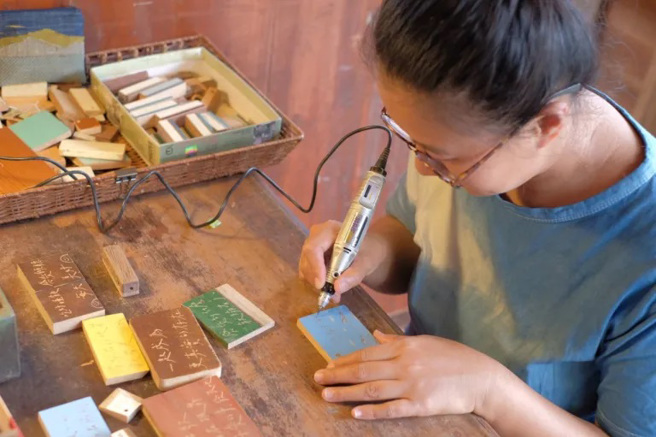 由以蹦整理廢木材、小朱親手刻寫出的動人詞句木牌，每款都是當下感動瞬間。(圖/行遍天下提供)