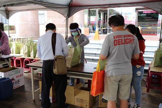 工作人員和民眾確認關懷包內容物。（蔡明亘攝）