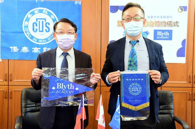 侨泰高中校长温顺德与布莱斯学院教育总监 Dr. Peter Chen交换两校锦旗。（侨泰高中提供／卢金足台中传真）