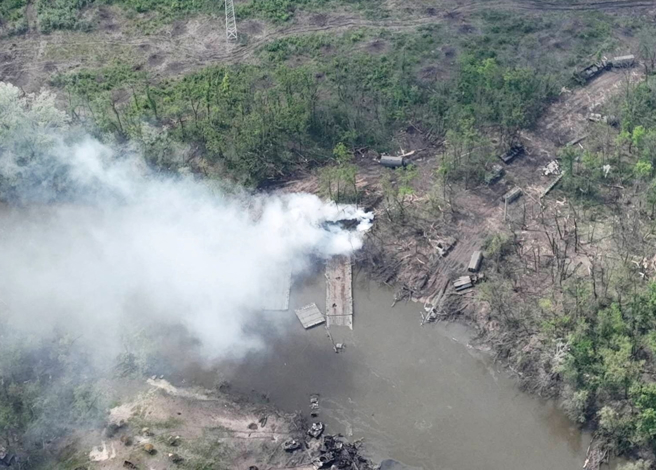 乌东北顿涅茨河（Siverskyi Donets River）的俄罗斯浮桥附近冒出阵阵浓烟。（乌克兰空降兵司令部/路透）