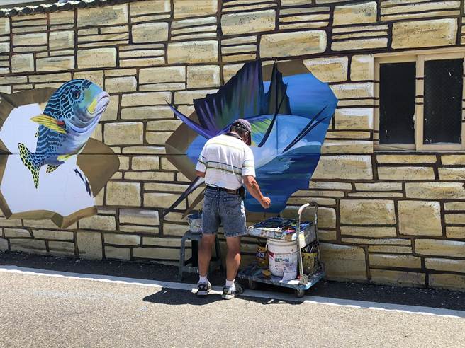 后龙镇水尾里社区请来彩绘师，帮社区画上渔村生活彩绘。（谢明俊摄）