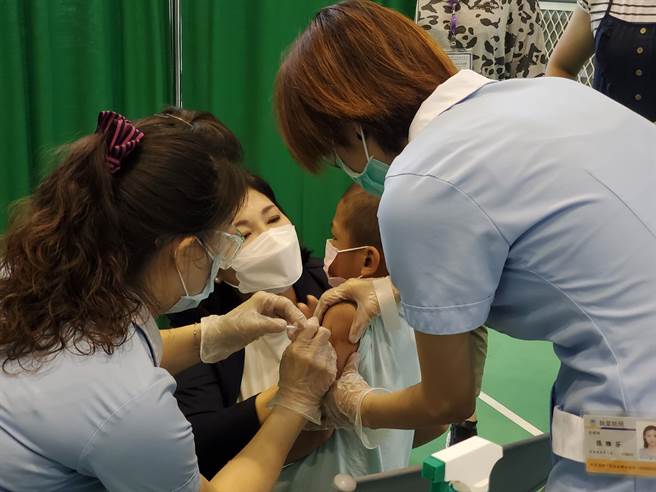 云林县长张丽善13日视察斗南镇大东国小疫苗接种作业，一名小男孩怕打针急哭了，张丽善陪他闯关直到打完。（周丽兰摄）