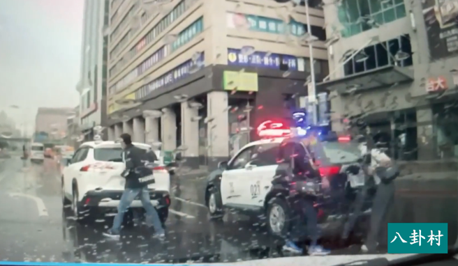 新聞台採訪車發生擦撞停在馬路中，女記者從採訪車下來後向員警說了一下，就直接與另名男攝影記者搭上警車離去，留下事故轎車不管。（翻攝自臉書「八卦村-行車紀錄器影片上傳中心」）