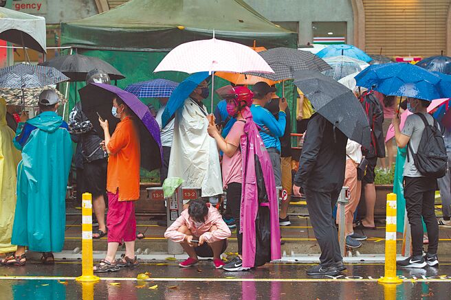 疫情持續升溫，新北市耕莘醫院防疫急門診12日有許多民眾大排長龍等待看診。（杜宜諳攝）