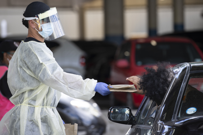 紐西蘭政府免費發送抗原快篩劑讓民眾自行檢測，減少了醫院的做初級檢測的負擔。圖為民眾在各地的篩檢站不下車就能取得快篩試劑。（圖／美聯社）