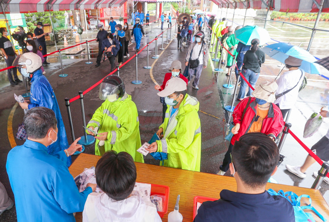 疫情升温，为防疫情扩散，快筛检测需求量大，各地纷现排队领快筛剂的现象。松山慈惠堂捐赠10000剂韩国制GenBody快筛，于14、15两日上下午各两个时段供民眾自由索取，每个时段各1000个名额，许多民眾一早即排队领取。（粘耿豪摄）