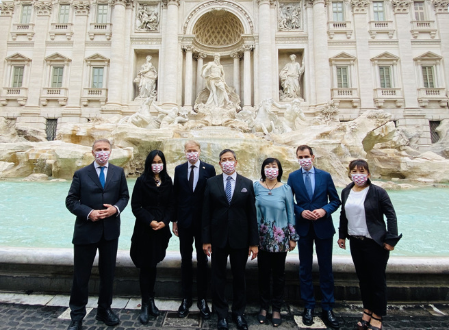 在駐義大利代表李新穎（中）的發起下，義國會友台協會主席馬蘭參議員（左3）、副主席迪馬尤眾議員（右2）、副主席帕賈諾眾議員（左），以及僑務顧問王美紅（右3）、羅馬中文學校校長湯美快（左2）及義大利羅馬台灣同鄉會會長羅容珍（右），齊聚許願池噴泉前，祈願台灣參與世衛。(圖／中央社)