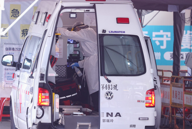 國內今日新增183例中重症個案。圖為救護車人員載送病患後，用酒精消毒車內各處。（羅永銘攝）