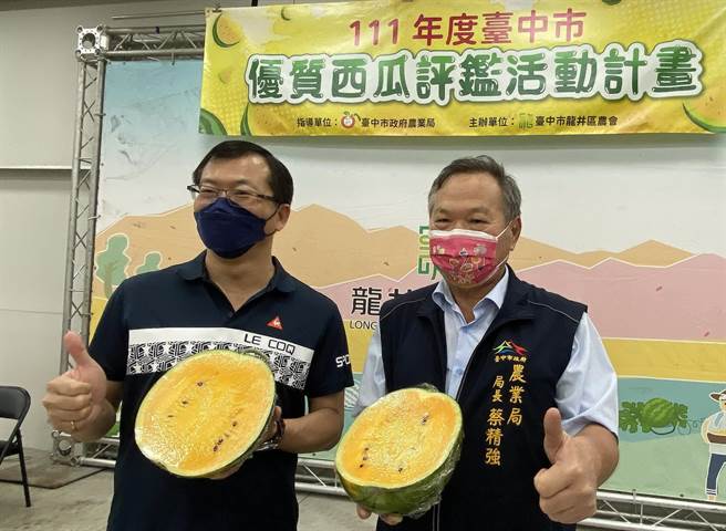 中市优质西瓜评鑑14日在龙井区农会举行，中市府农业局长蔡精强（右）及龙井区农会总干事林裕议（左）推荐台中西瓜肉质细致、清甜美味。（陈淑芬摄）