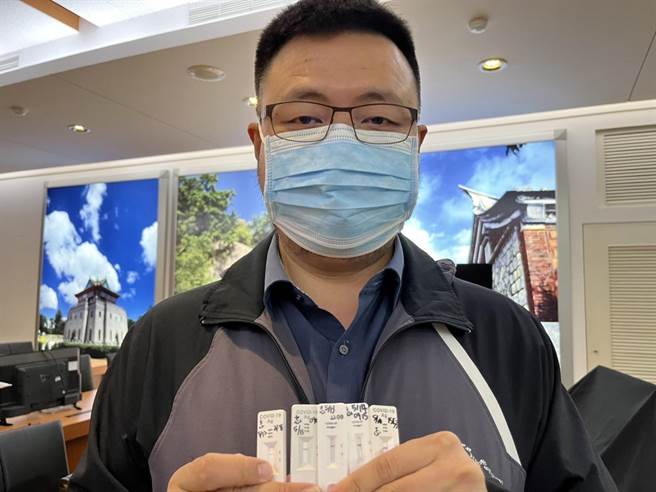 金门县长办公室主任陈志斌拿出自己的快筛阴性证明，强调确有做好相关防疫应变工作。（金门县府提供）