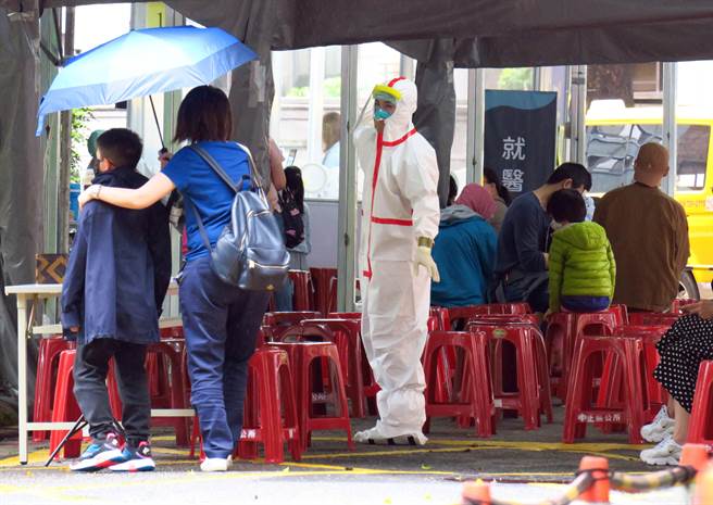 台北市立联合医院妇幼院区亲子儿童防疫急门诊，设于巷弄内大楼间的户外广场，医护人员身穿防护装指引就诊民眾。（姚志平摄）