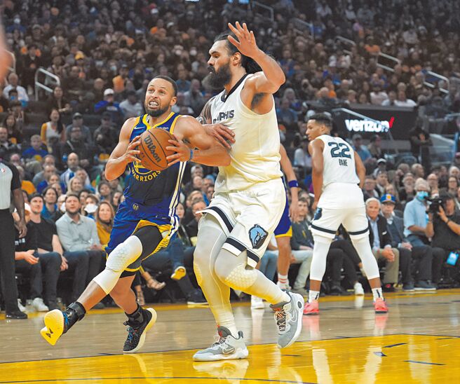 勇士射手柯瑞（左）在灰熊中鋒亞當斯的防守下強行切入。（美聯社）