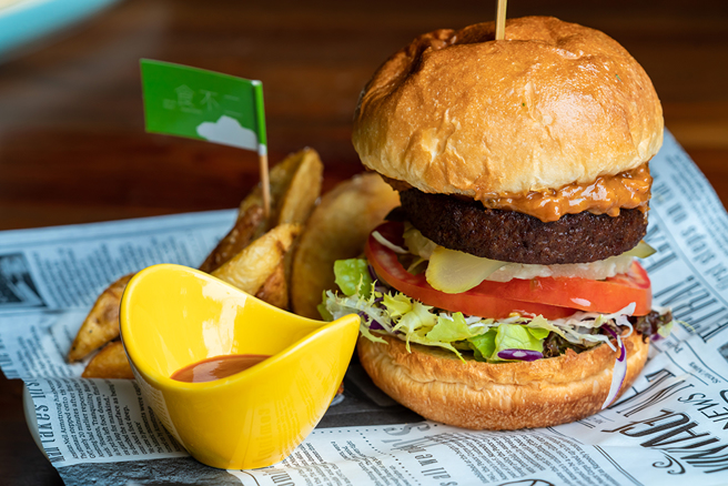 戴上手套豪迈举起「香浓花生大汉堡」，不顾形象的大口咬下最过瘾。(摄影/Cindy Lee)
