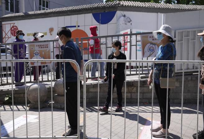 上海民眾在歷經封城生活的艱苦掙扎之後，大量中上層人士萌生移民念頭，社交媒體與網路上「移民」的搜尋快速增加。圖為上海民眾每天都需要進行的排隊做核酸檢測 。（圖／美聯社）