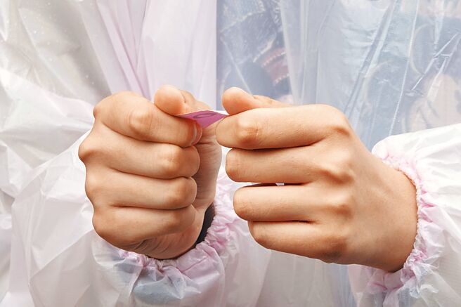 台北市松山慈惠堂發放免費快篩試劑給民眾，取得廟方工作人員發放號碼牌的民眾緊緊握著牌子。（黃子明攝）