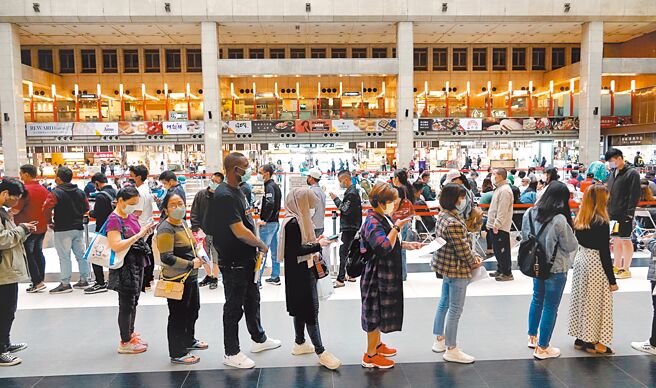 新冠肺炎本土疫情持续严峻，连日来确诊病例数突破6万，台北车站大厅的疫苗接种站15日涌入数百人排队施打。（黄世麒摄）